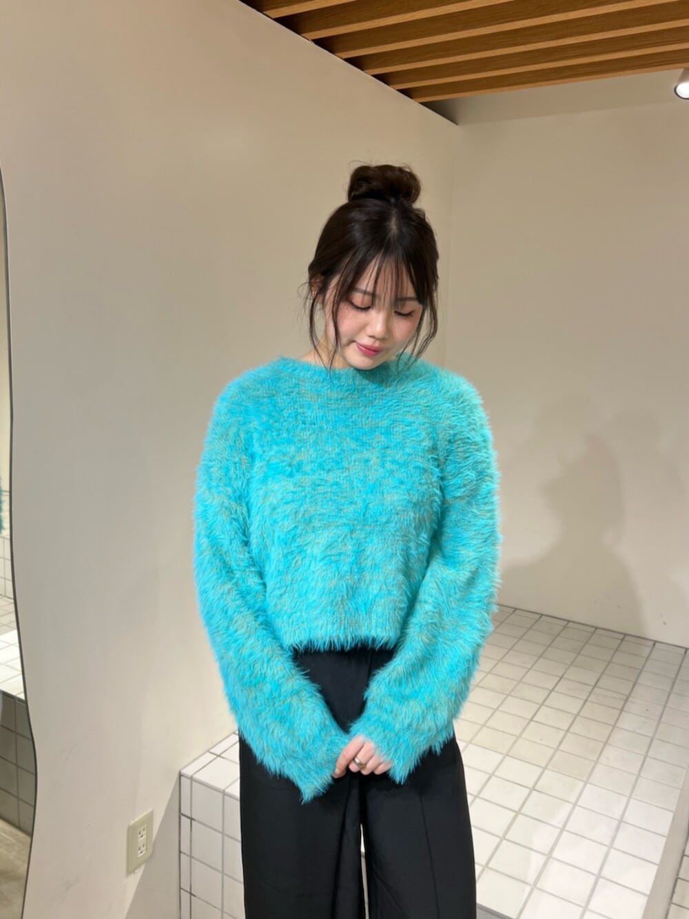 ブルー系のニット/セーター、ブラック系のブーツ、ブラック系のその他パンツを着用したレディースの冬コーディネートの3枚目の写真