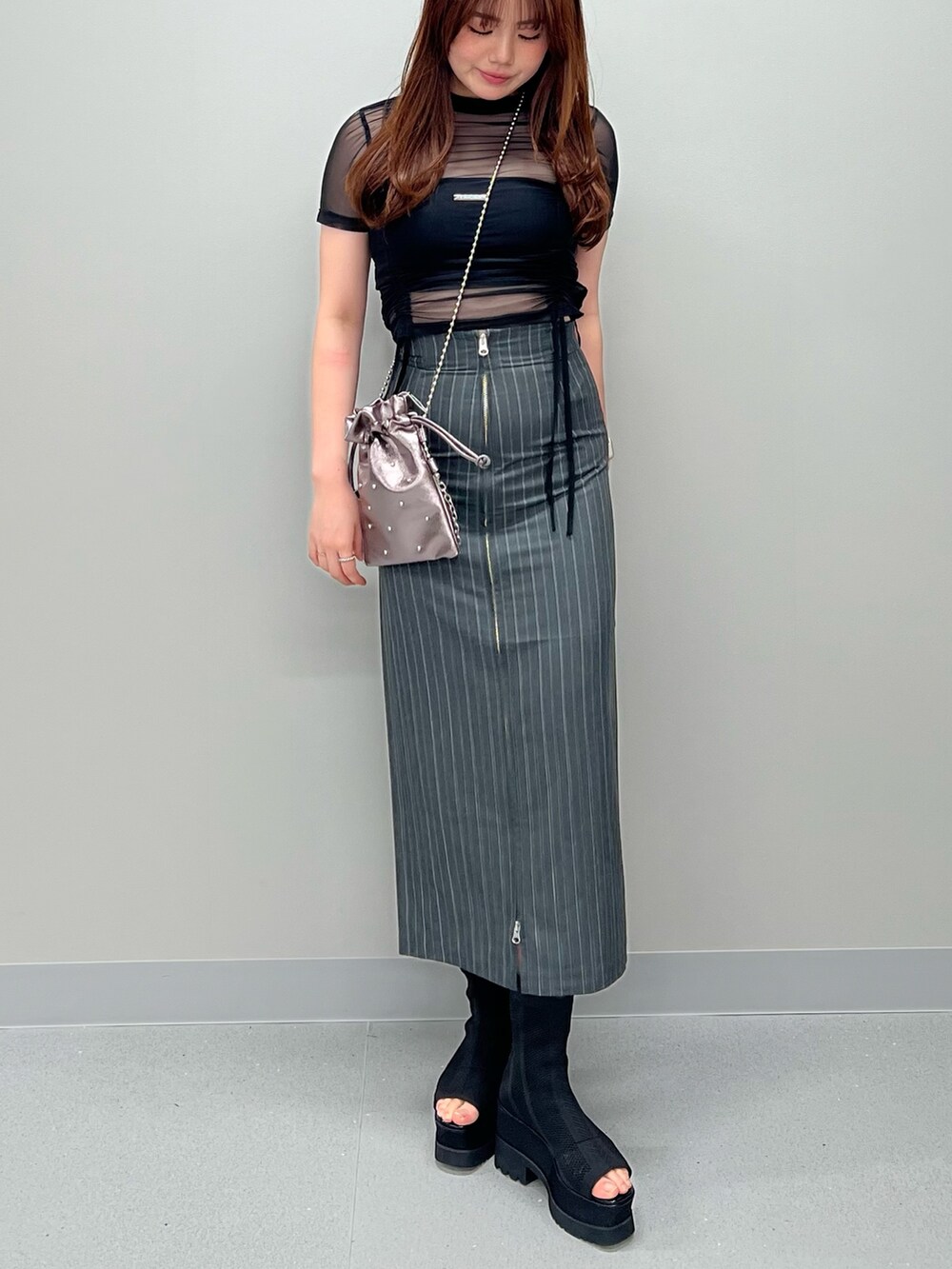 グレー系のスカート、ブラック系のチューブトップ、ブラック系のTシャツ/カットソーを着用したレディースの春コーディネートの4枚目の写真