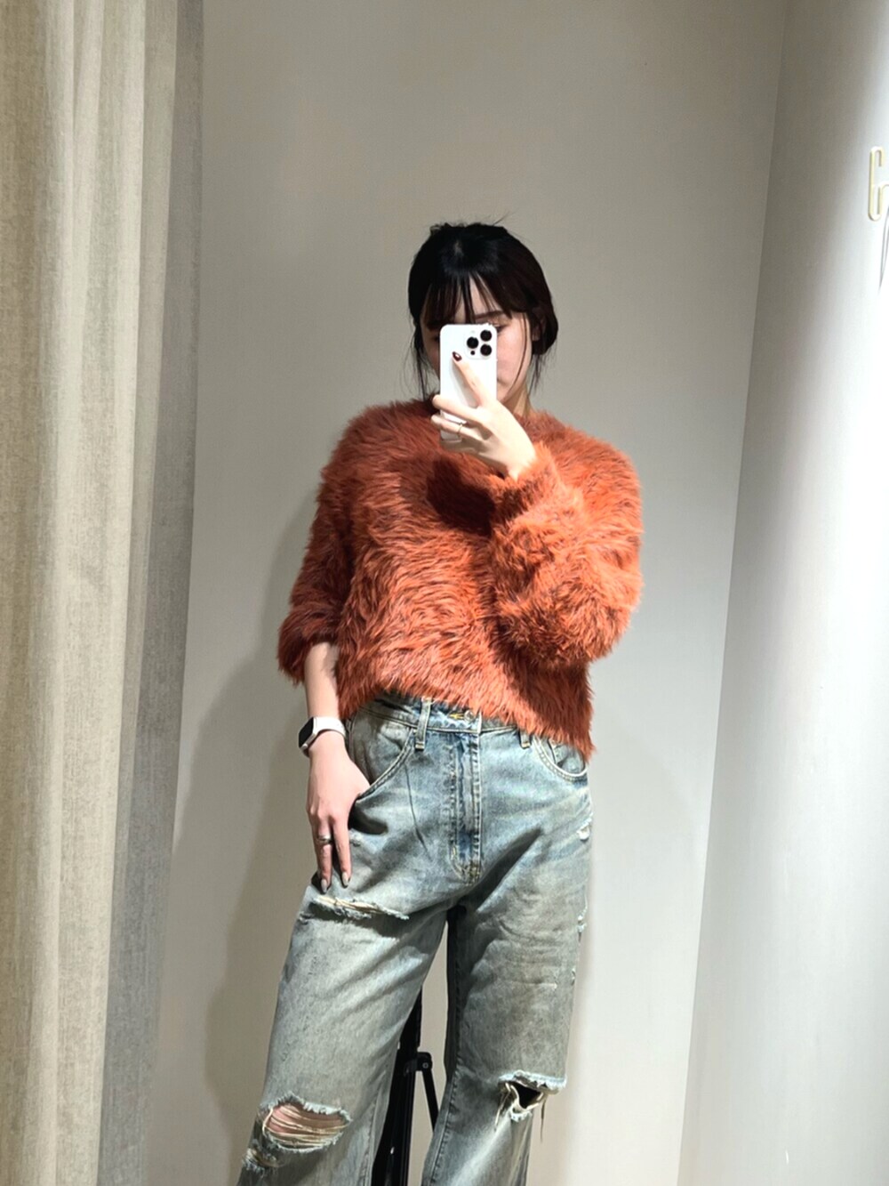 ブルー系のデニムパンツ、オレンジ系のニット/セーター、ブラウン系のサンダルを着用したレディースの秋コーディネートの5枚目の写真
