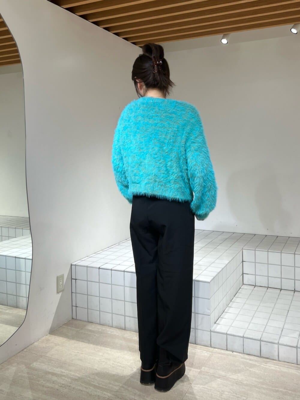 ブルー系のニット/セーター、ブラック系のブーツ、ブラック系のその他パンツを着用したレディースの冬コーディネートの4枚目の写真