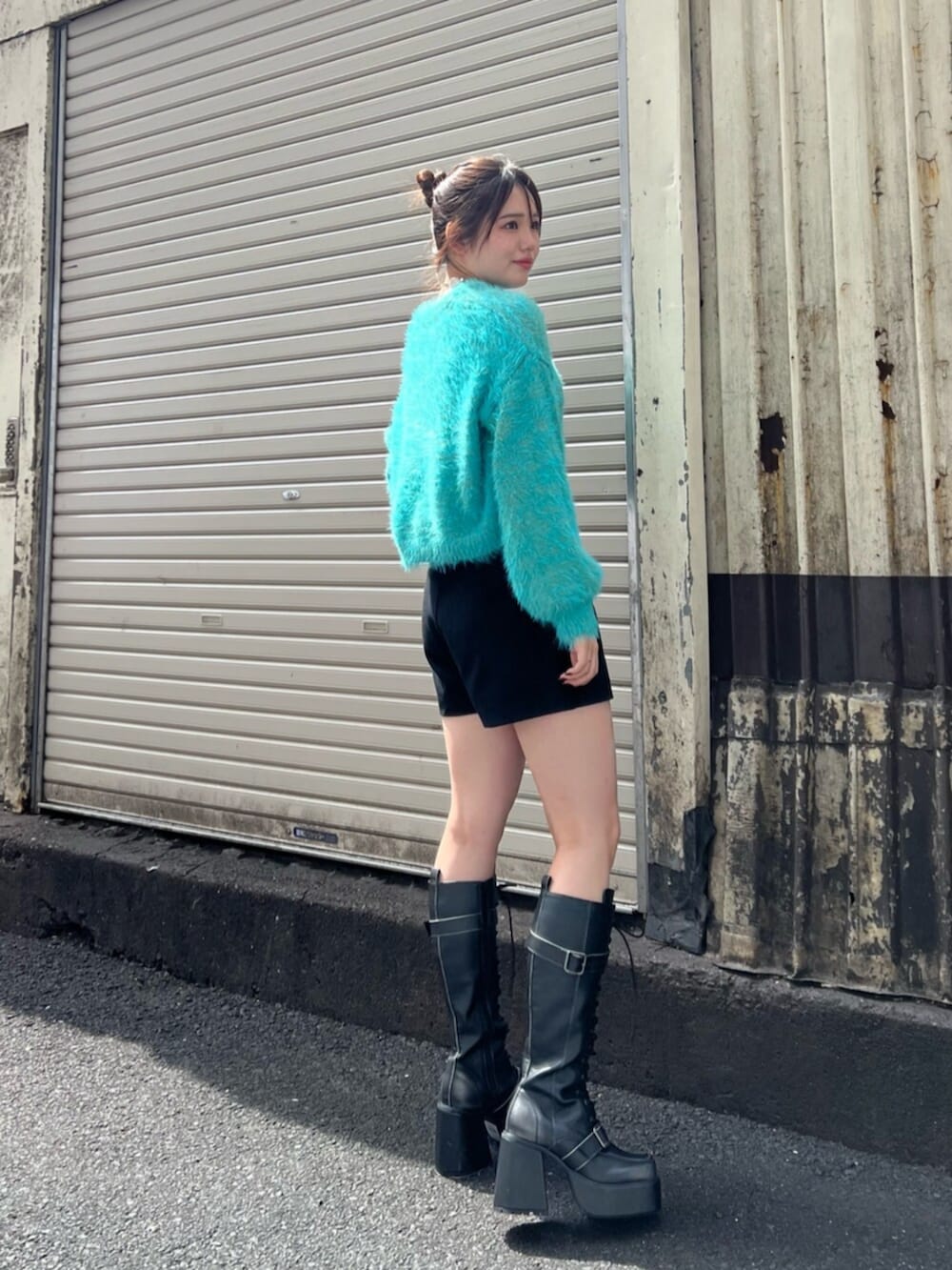 ブラック系のブーツ、ブラック系のその他パンツ、ブルー系のニット/セーターを着用したレディースの秋コーディネートの3枚目の写真