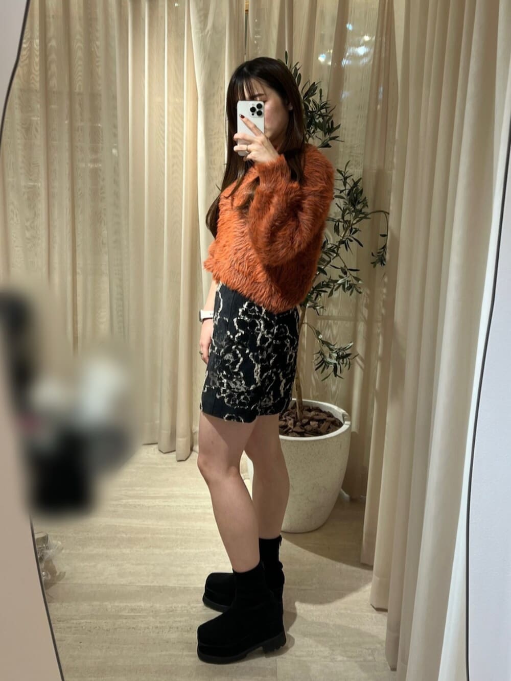 ブラック系のブーツ、ブラック系のスカート、グレー系のニット/セーターを着用したレディースの秋コーディネートの2枚目の写真