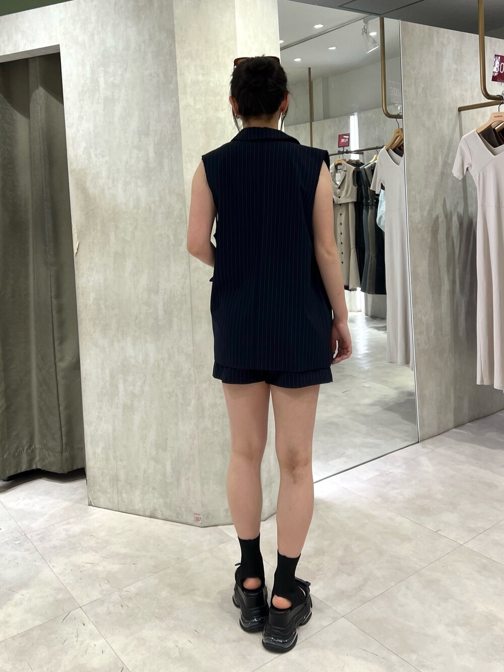 ホワイト系のタンクトップ、ブラック系のサンダル、ブルー系のその他パンツを着用したレディースの夏コーディネートの4枚目の写真