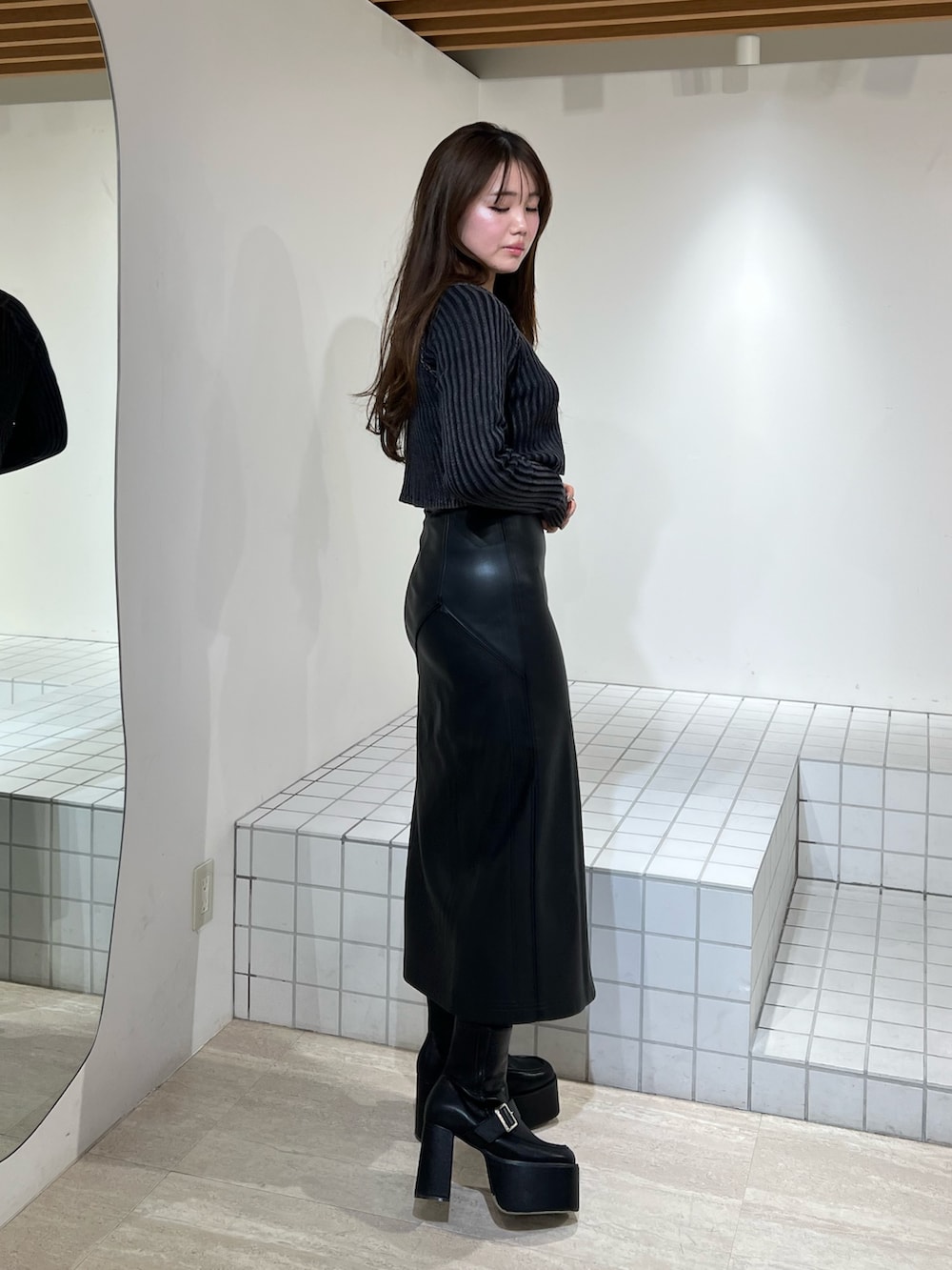 ブラック系のブーツ、ブラック系のニット/セーター、ブラック系のスカートを着用したレディースの冬コーディネートの3枚目の写真