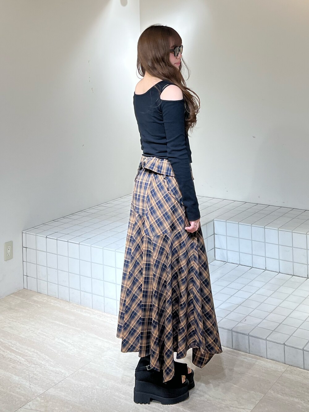 ブラック系のブーツ、ブラック系のワンピース、ブラック系のニット/セーターを着用したレディースの春コーディネートの3枚目の写真