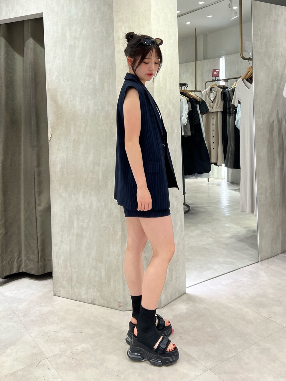 ホワイト系のタンクトップ、ブラック系のサンダル、ブルー系のその他パンツを着用したレディースの夏コーディネートの2枚目の写真