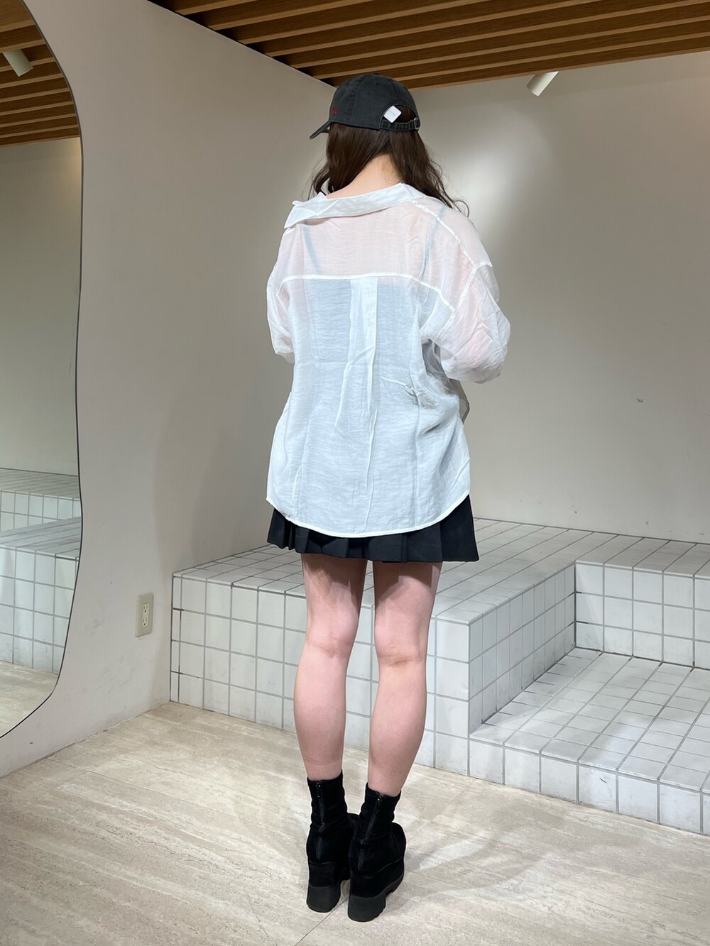ブラック系のブーツ、ブラック系のスカート、ブラック系のキャミソールを着用したレディースの春コーディネートの4枚目の写真