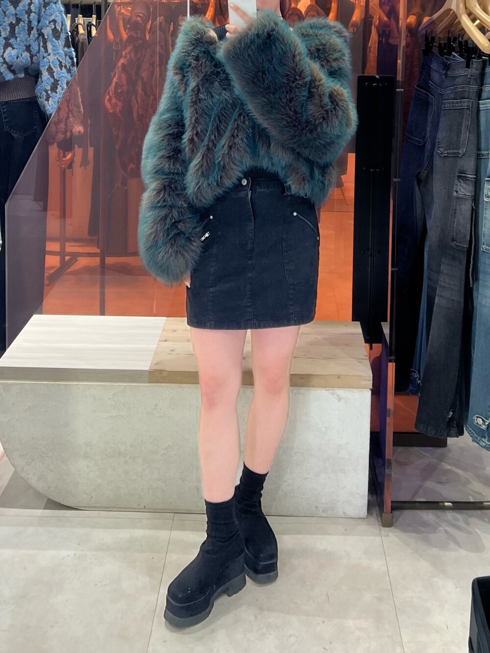 ブラック系のブーツ、ブルー系のブルゾン、ブラック系のスカートを着用したレディースの秋コーディネートの4枚目の写真