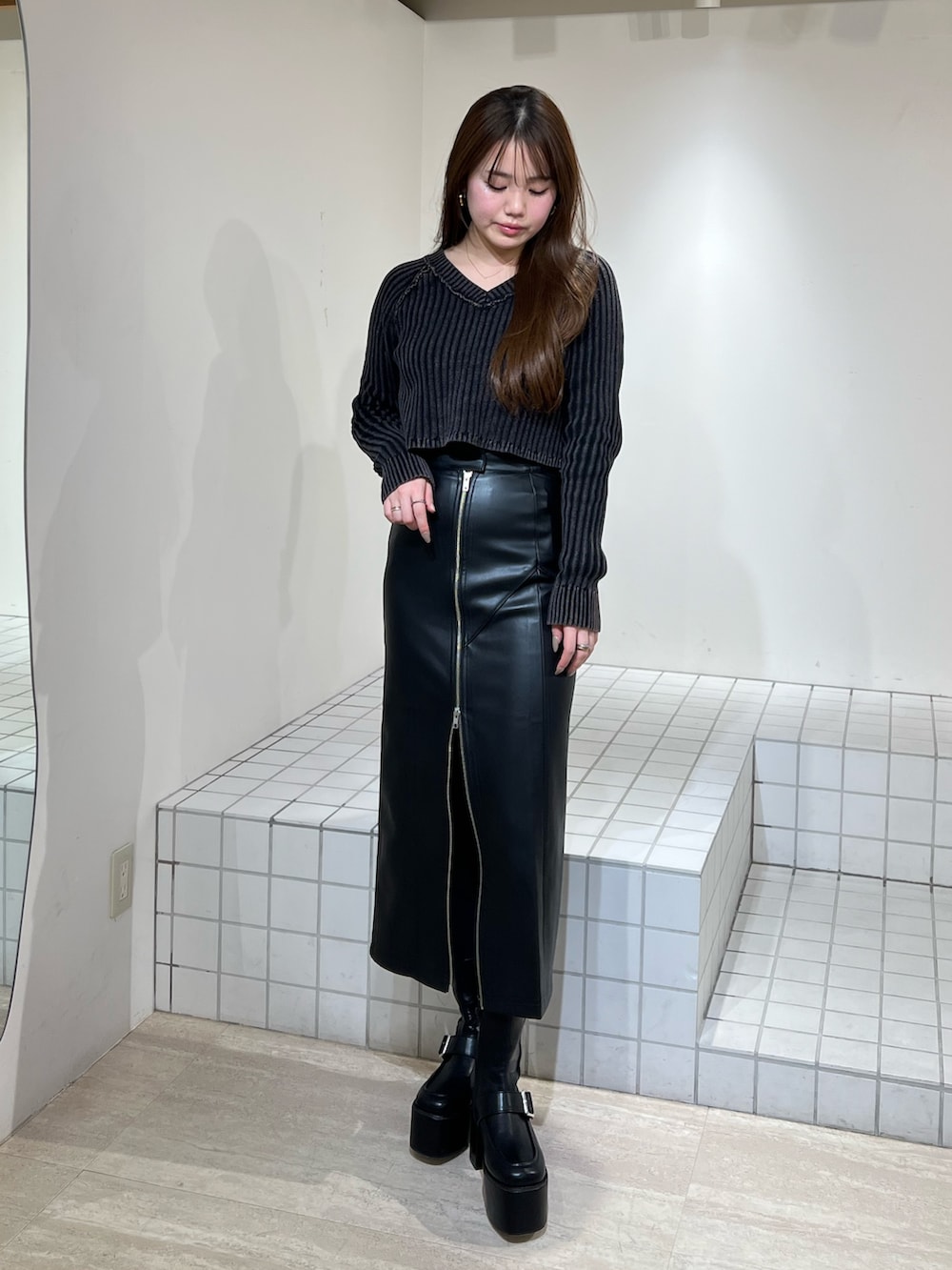 ブラック系のブーツ、ブラック系のニット/セーター、ブラック系のスカートを着用したレディースの冬コーディネートの6枚目の写真