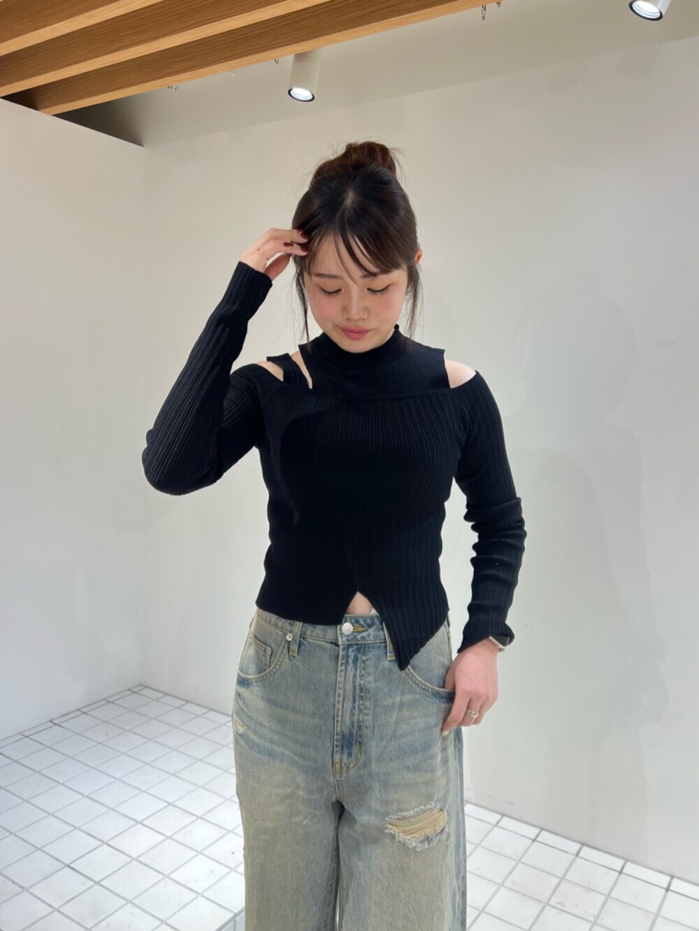 ブラック系のサンダル、ブルー系のデニムパンツ、ブラック系のニット/セーターを着用したレディースの秋コーディネートの4枚目の写真