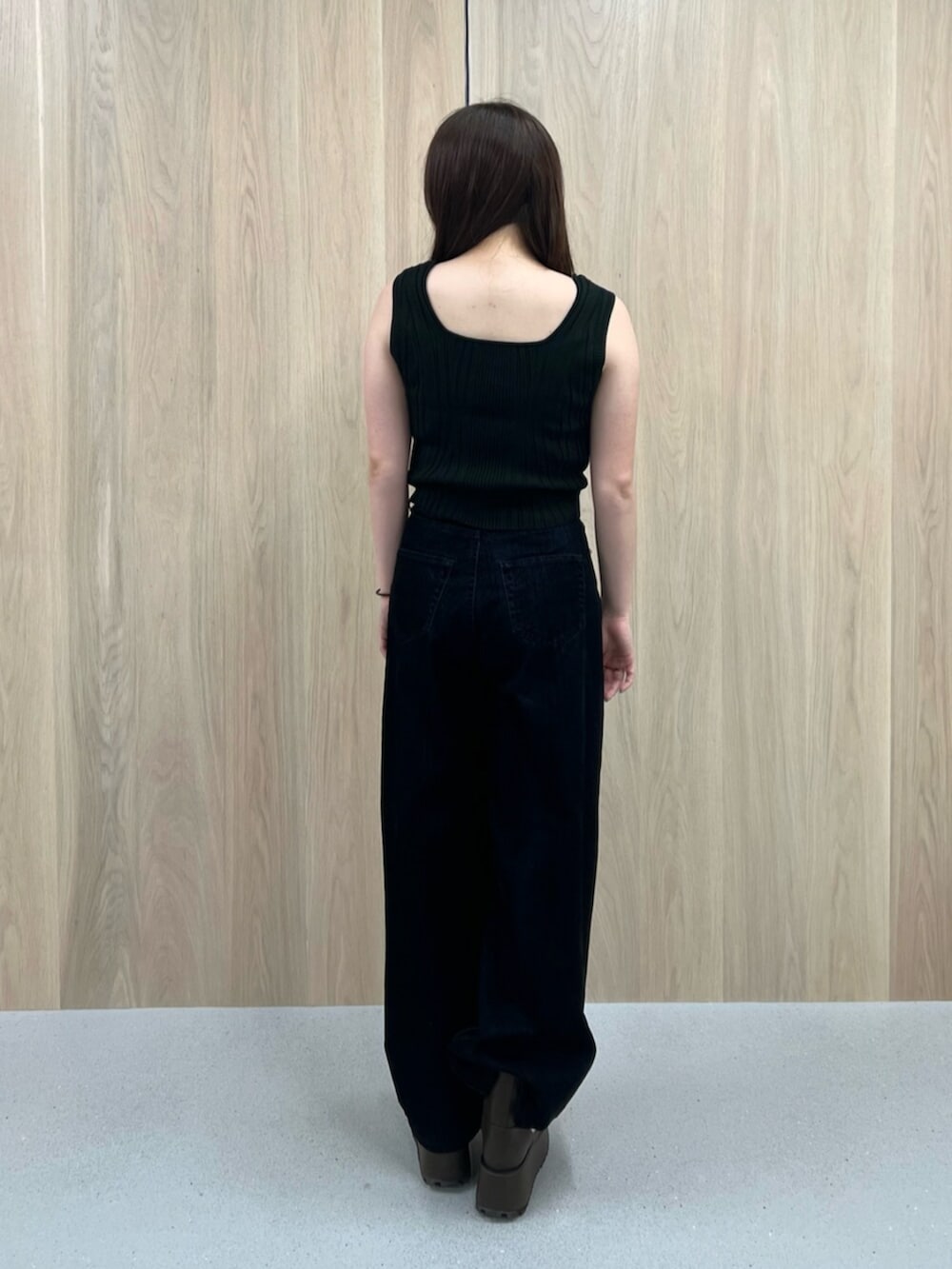 ホワイト系のタンクトップ、ブラウン系のブーツ、ブラック系のデニムパンツを着用したレディースの夏コーディネートの3枚目の写真