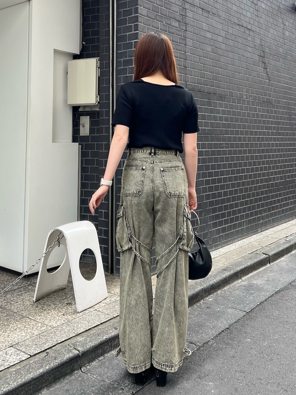 ブラック系のサンダル、ブラック系のハンドバッグ、ブラック系のニット/セーターを着用したレディースの夏コーディネートの3枚目の写真