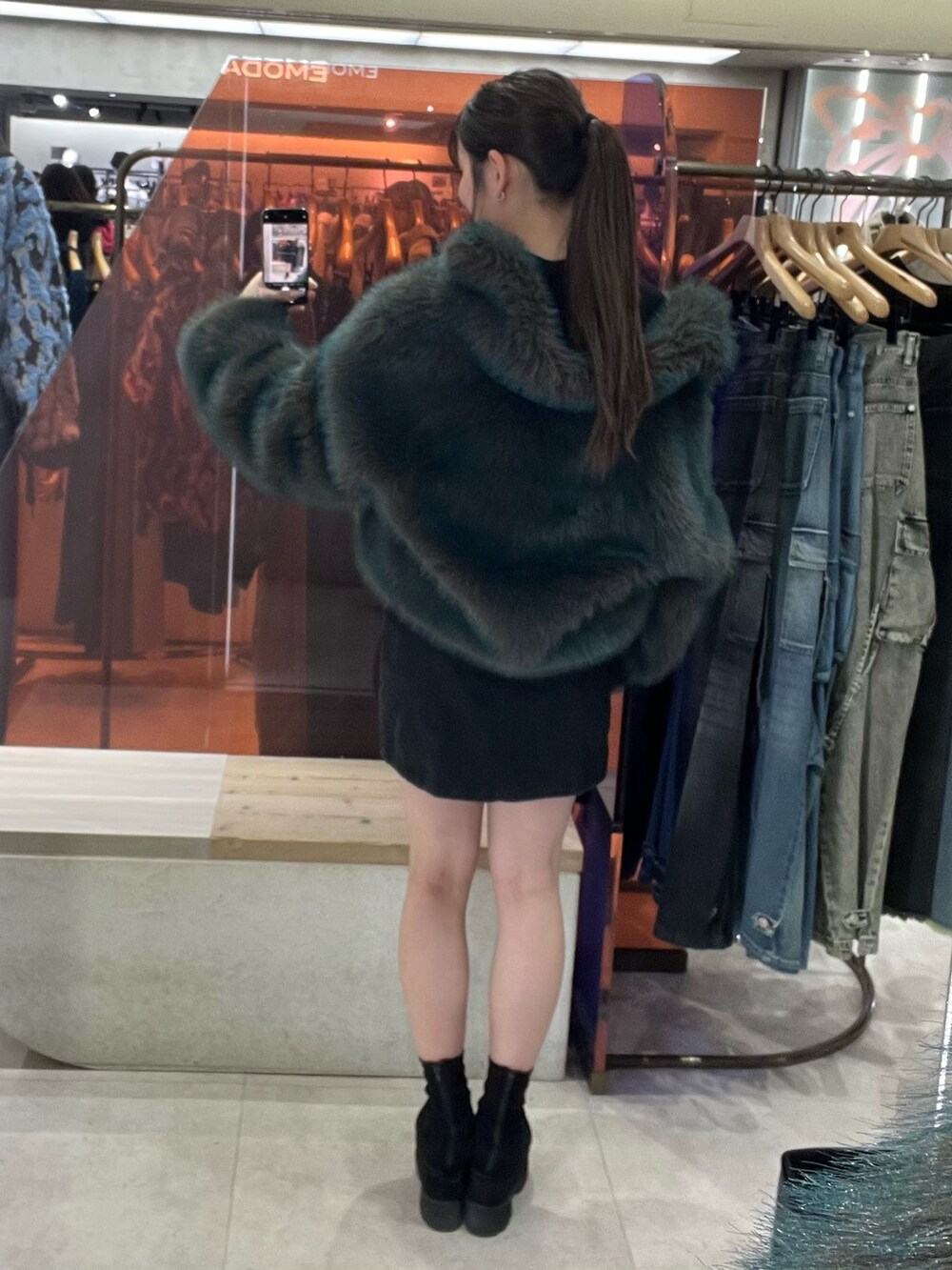 ブラック系のブーツ、ブルー系のブルゾン、ブラック系のスカートを着用したレディースの秋コーディネートの5枚目の写真