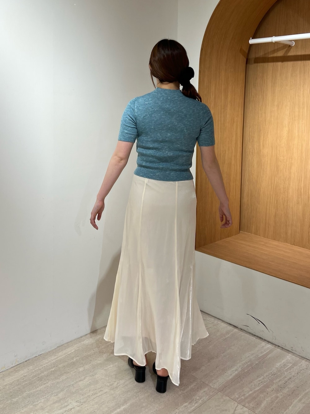 ブラック系のパンプス、ホワイト系のスカート、ブルー系のニット/セーターを着用したレディースの夏コーディネートの3枚目の写真