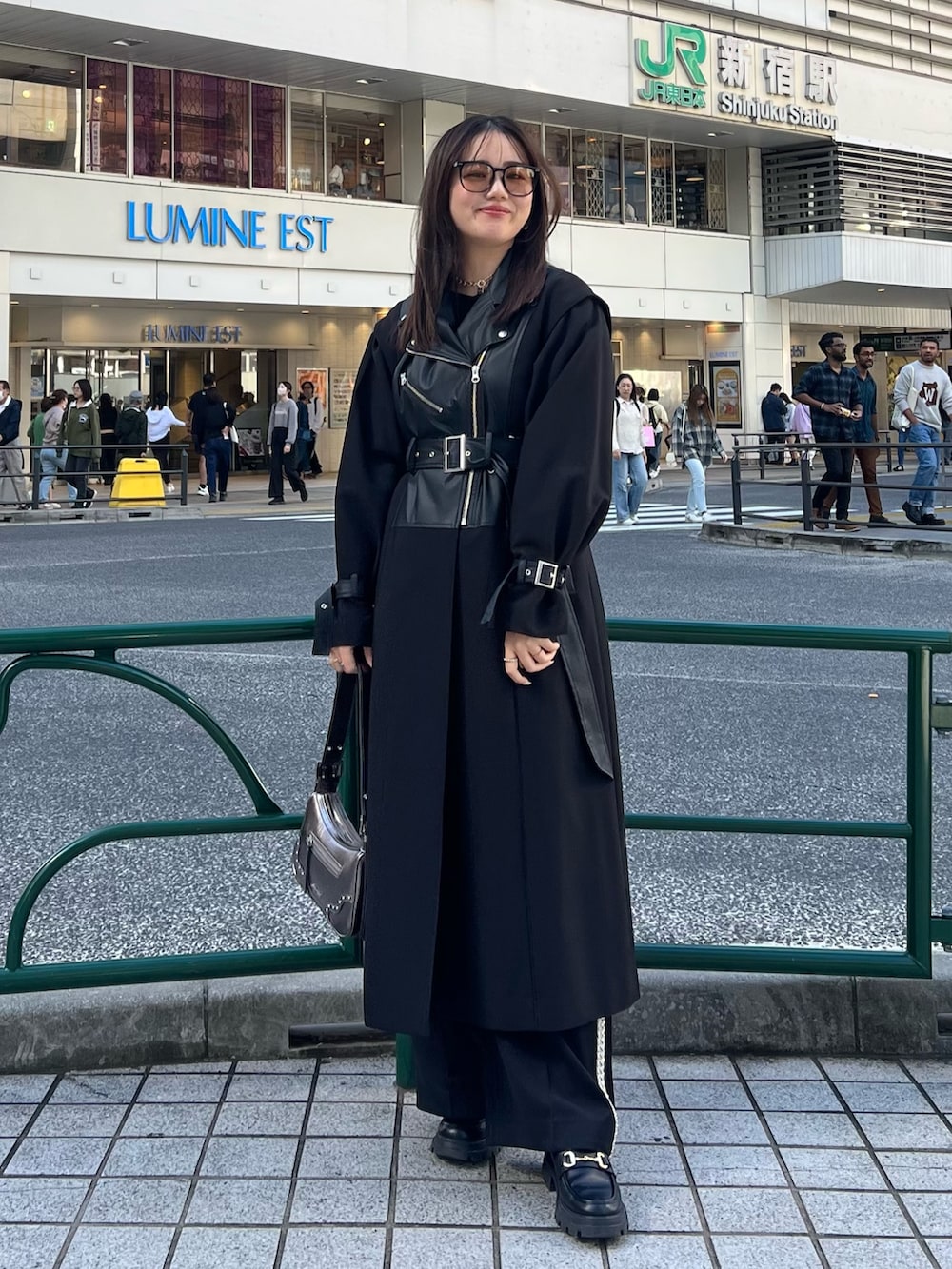 ブラック系のその他パンツ、ブラック系のトレンチコート、ゴールド系のハンドバッグを着用したレディースの秋コーディネートの4枚目の写真