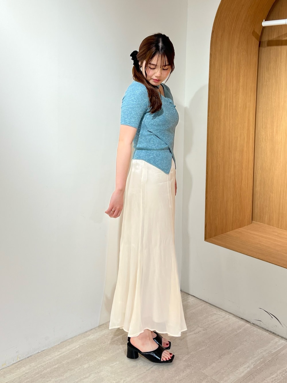 ブラック系のパンプス、ホワイト系のスカート、ブルー系のニット/セーターを着用したレディースの夏コーディネートの2枚目の写真