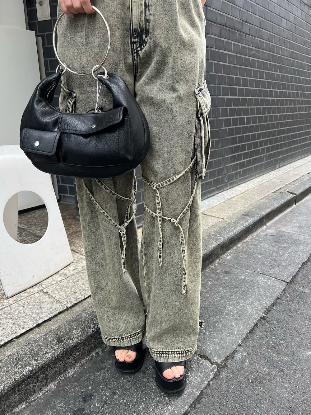 ブラック系のサンダル、ブラック系のハンドバッグ、ブラック系のニット/セーターを着用したレディースの夏コーディネートの5枚目の写真