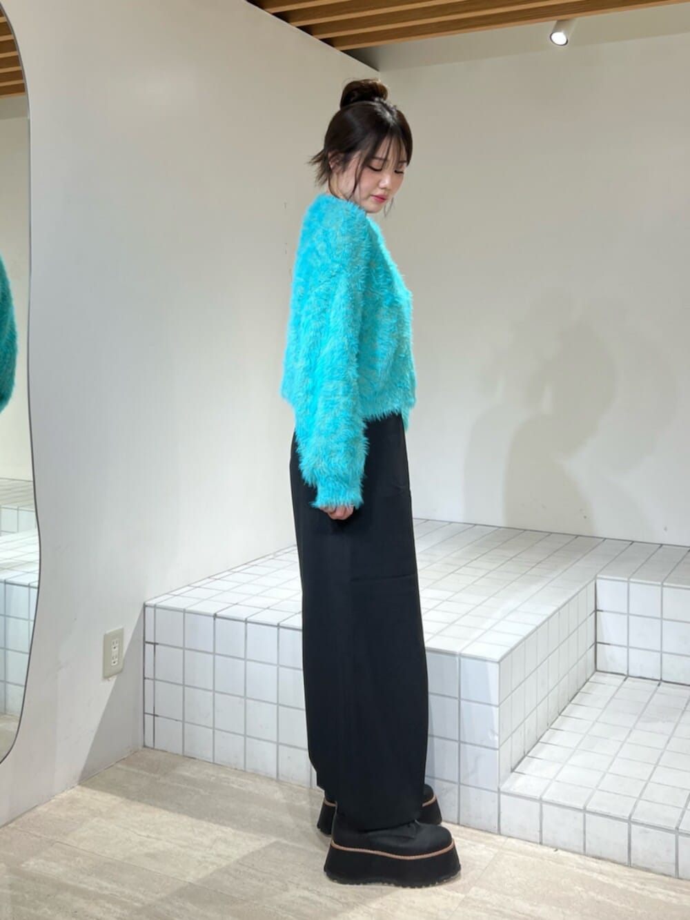 ブルー系のニット/セーター、ブラック系のブーツ、ブラック系のその他パンツを着用したレディースの冬コーディネートの2枚目の写真