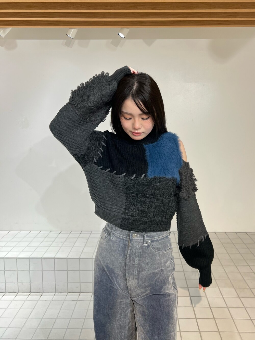 ブラック系のブーツ、グレー系のデニムパンツ、ブラック系のニット/セーターを着用したレディースの秋コーディネートの4枚目の写真