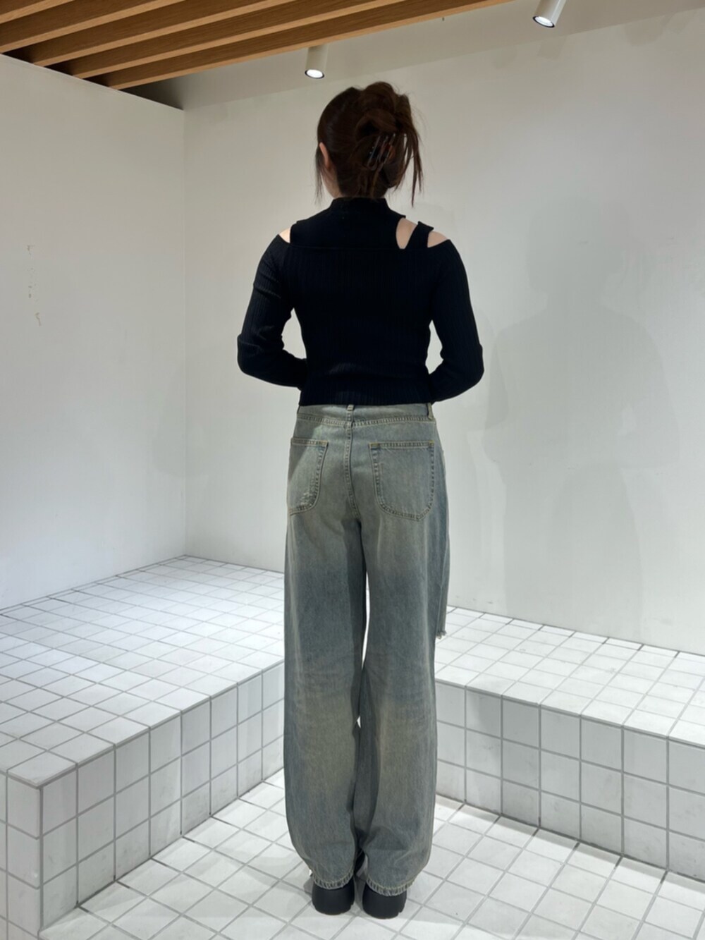 ブラック系のサンダル、ブルー系のデニムパンツ、ブラック系のニット/セーターを着用したレディースの秋コーディネートの3枚目の写真