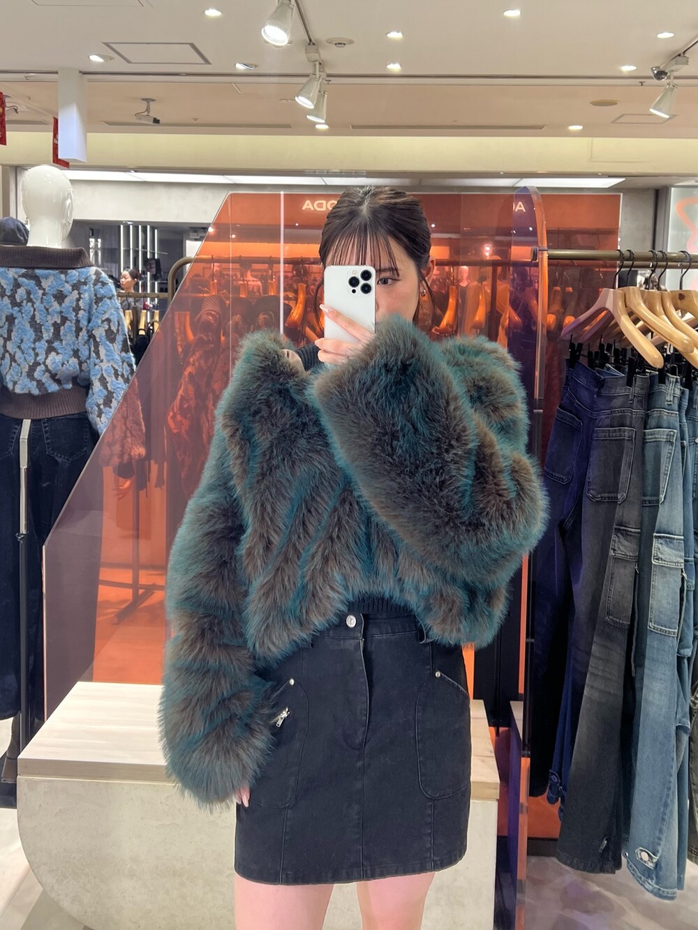 ブラック系のブーツ、ブルー系のブルゾン、ブラック系のスカートを着用したレディースの秋コーディネートの2枚目の写真