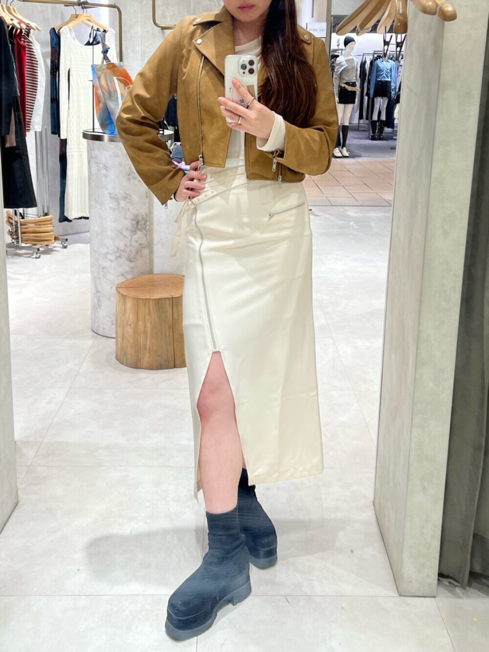 ブラック系のブーツ、ホワイト系のTシャツ/カットソー、イエロー系のライダースジャケットを着用したレディースの春コーディネートの3枚目の写真