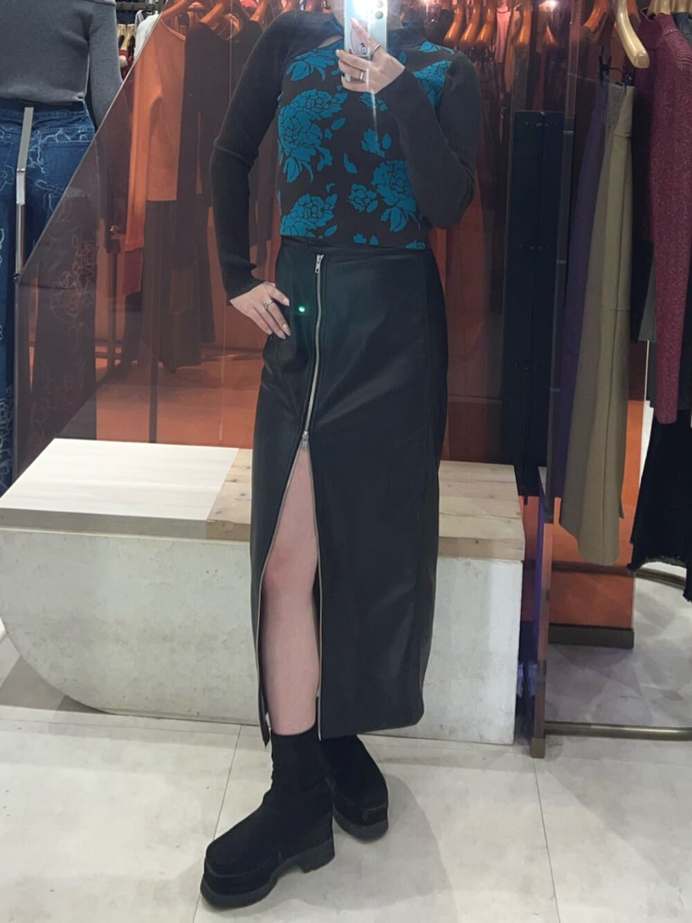 ブラック系のブーツ、ブラック系のスカート、その他のニット/セーターを着用したレディースの冬コーディネートの6枚目の写真