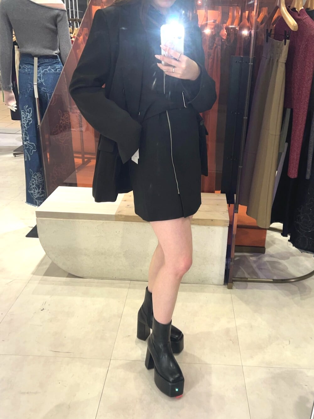 ブラック系のブーツ、ブラック系のワンピース、ブラック系のテーラードジャケットを着用したレディースの冬コーディネートの5枚目の写真