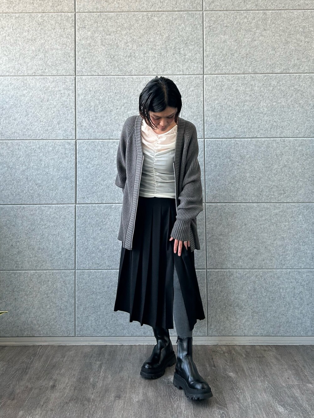 ブラック系のスカート、ホワイト系のTシャツ/カットソー、グレー系のカーディガン/ボレロを着用したレディースの冬コーディネートの4枚目の写真