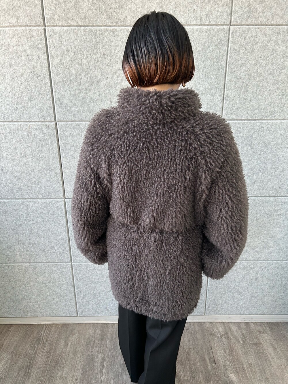 ホワイト系のニット/セーター、グレー系のその他アウター、ブラック系のその他パンツを着用したレディースの冬コーディネートの4枚目の写真