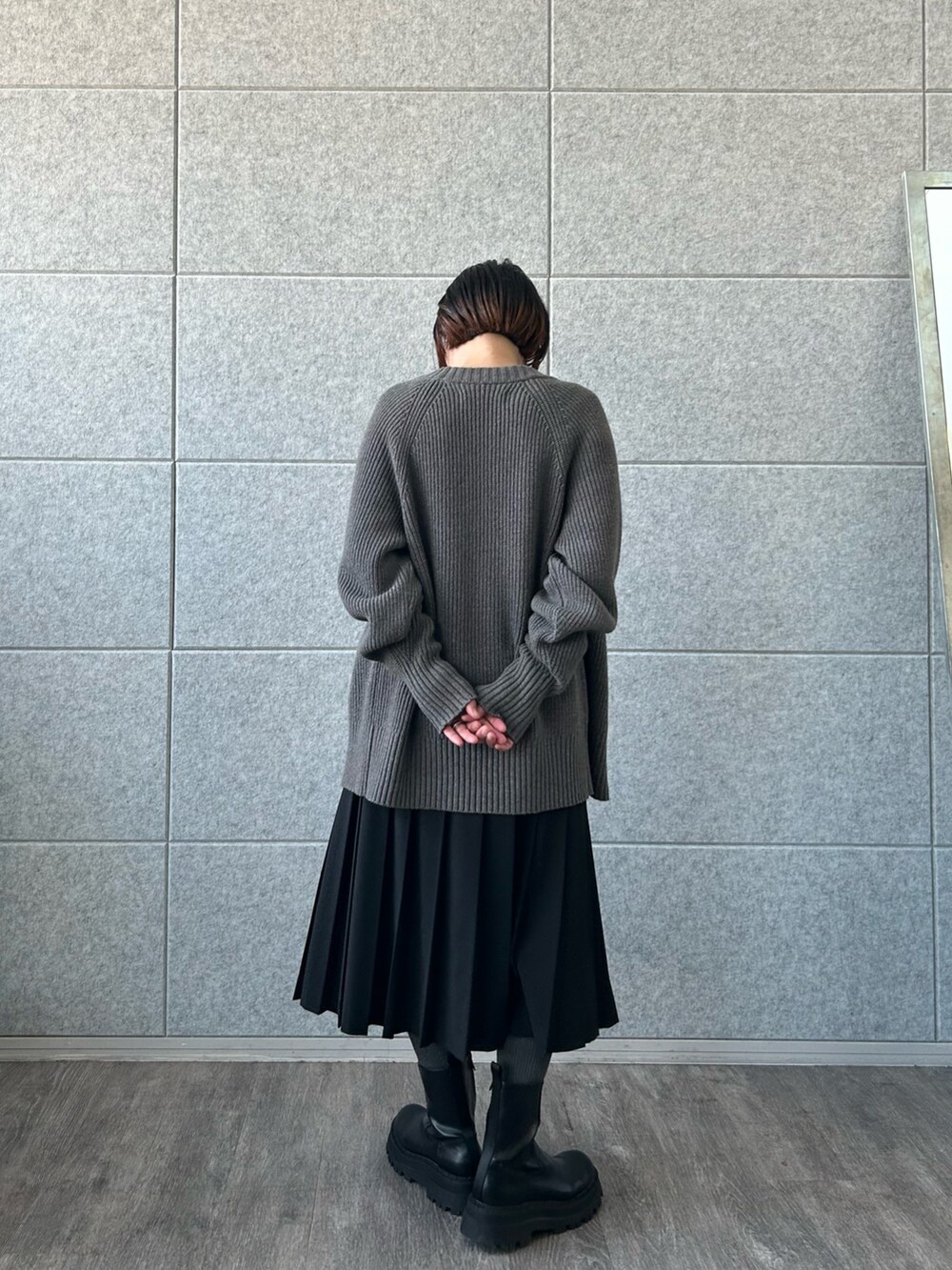 ブラック系のスカート、ホワイト系のTシャツ/カットソー、グレー系のカーディガン/ボレロを着用したレディースの冬コーディネートの3枚目の写真