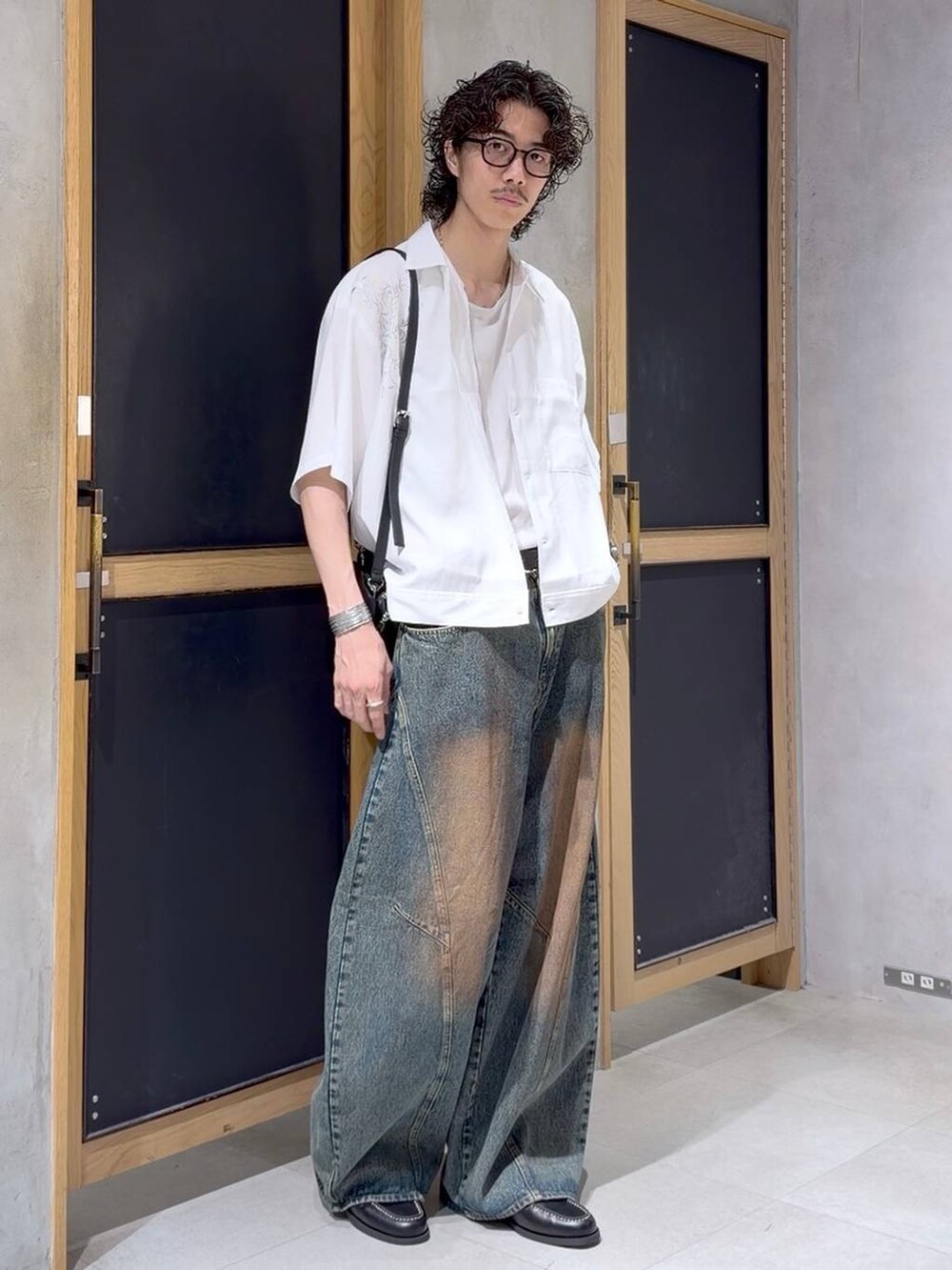 ブラック系のショルダーバッグ、ブラック系のモカシン/デッキシューズ、ホワイト系のタンクトップを着用したメンズの夏コーディネートの2枚目の写真