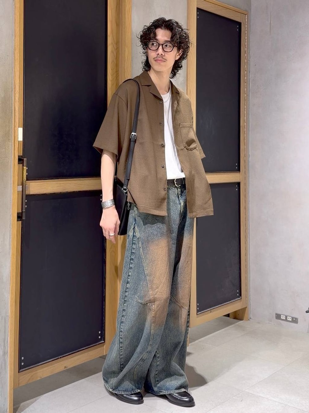 ブラック系のショルダーバッグ、ブラウン系のシャツ/ブラウス、ブラック系のローファーを着用したメンズの夏コーディネートの2枚目の写真