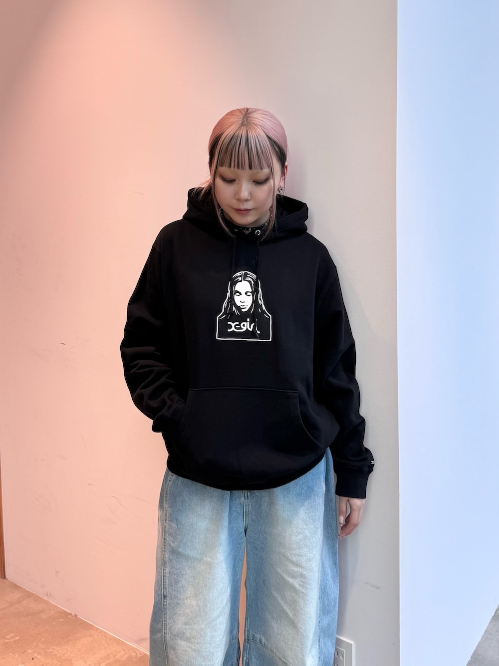 ブラック系のパーカー、ブルー系のデニムパンツ、ブラウン系のショルダーバッグを着用したレディースの冬コーディネートの3枚目の写真