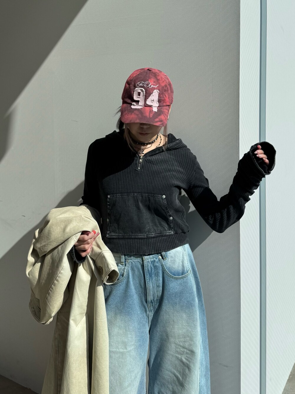 ブルー系のデニムパンツ、ブラック系のパーカー、ベージュ系のトレンチコートを着用したレディースの冬コーディネートの7枚目の写真