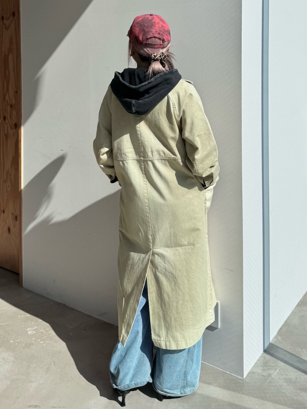 ブルー系のデニムパンツ、ブラック系のパーカー、ベージュ系のトレンチコートを着用したレディースの冬コーディネートの4枚目の写真