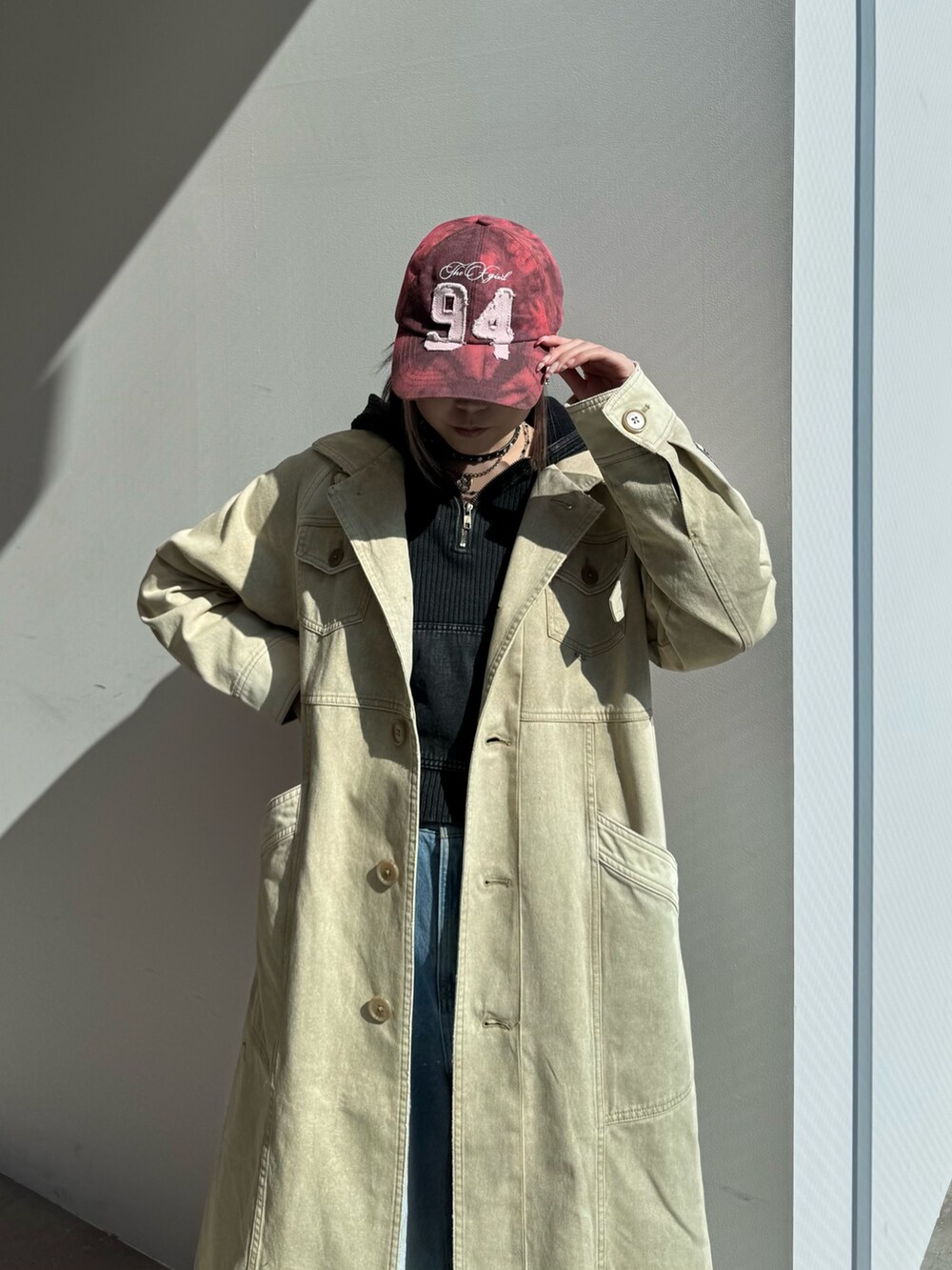 ブルー系のデニムパンツ、ブラック系のパーカー、ベージュ系のトレンチコートを着用したレディースの冬コーディネートの5枚目の写真