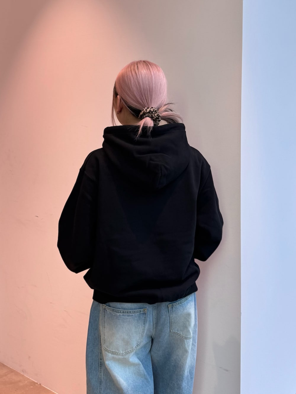 ブラック系のパーカー、ブルー系のデニムパンツ、ブラウン系のショルダーバッグを着用したレディースの冬コーディネートの4枚目の写真