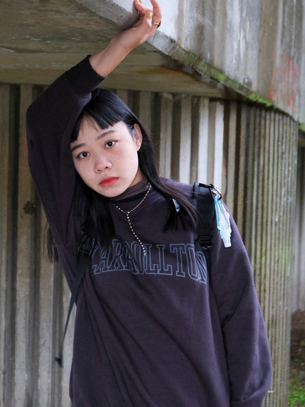 ブラック系のスウェット、ブラック系のバックパック/リュック、グリーン系のスカートを着用したレディースの冬コーディネートの2枚目の写真