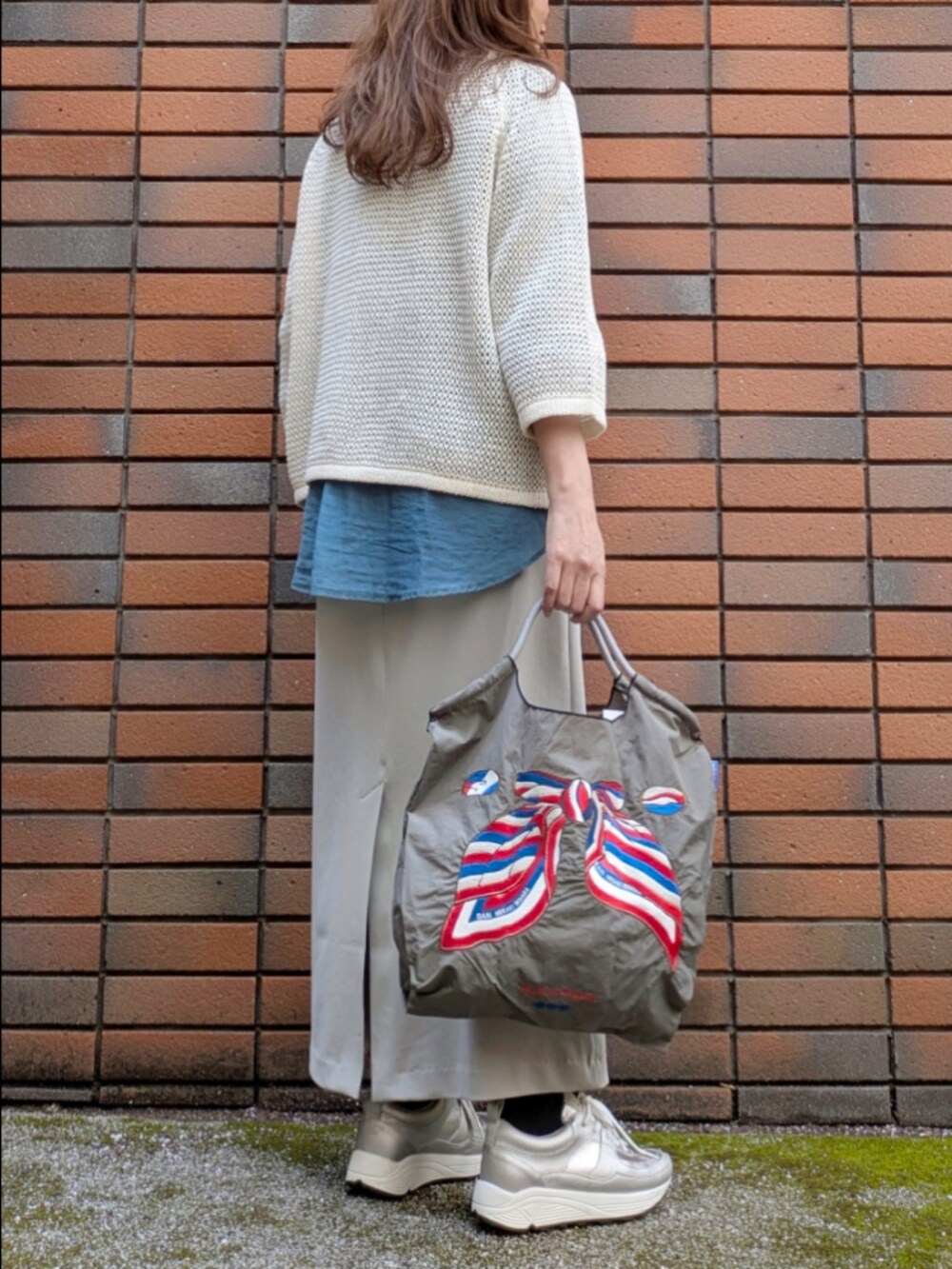 ブルー系のシャツ/ブラウス、ホワイト系のニット/セーターを着用したレディースの春コーディネートの2枚目の写真
