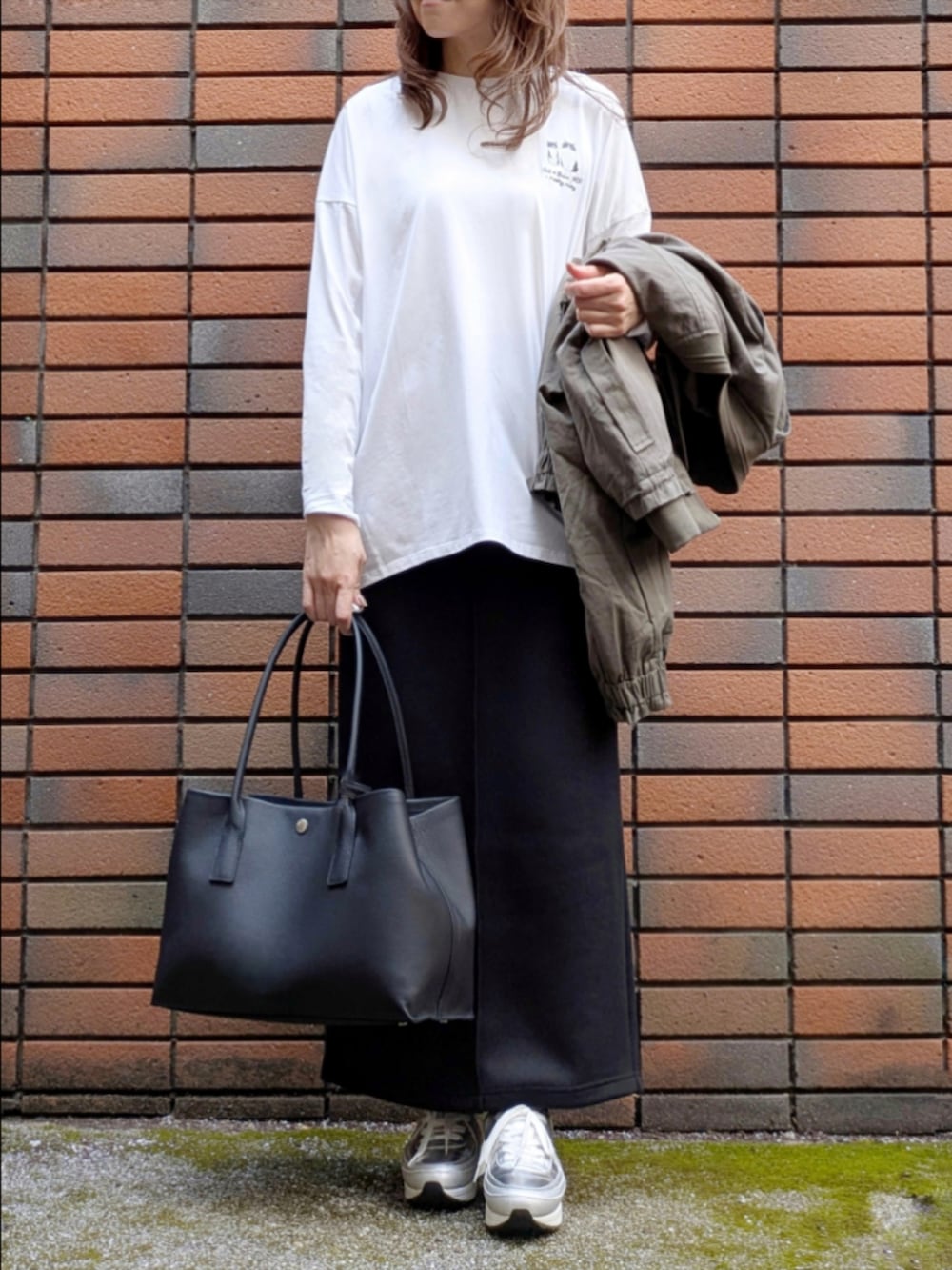 ブラック系のスカート、ホワイト系のTシャツ/カットソーを着用したレディースの冬コーディネートの6枚目の写真