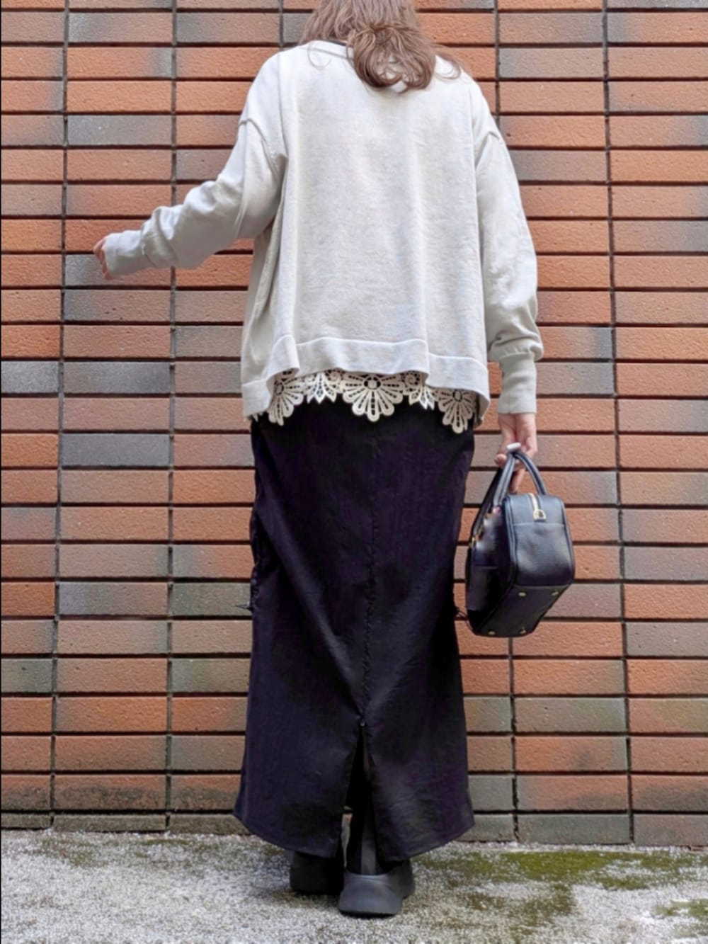 グレー系のニット/セーター、ベージュ系のTシャツ/カットソー、ブラック系のスカートを着用したレディースの冬コーディネートの7枚目の写真