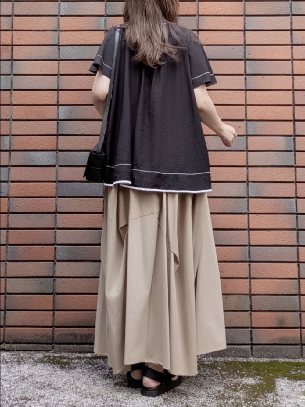 ブラック系のシャツ/ブラウス、ブラック系のショルダーバッグ、ベージュ系のスカートを着用したレディースの夏コーディネートの5枚目の写真