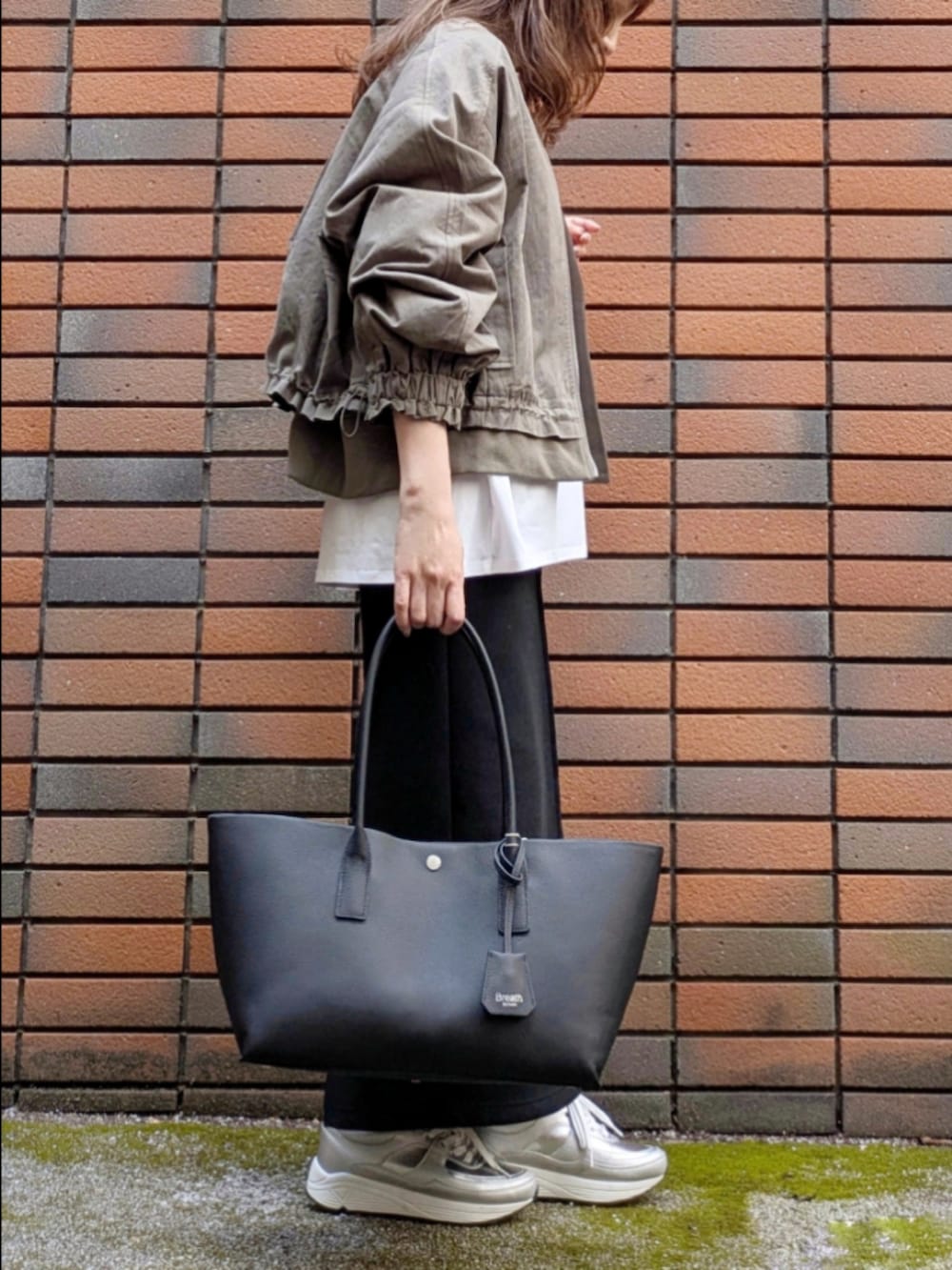 ブラック系のスカート、ホワイト系のTシャツ/カットソーを着用したレディースの冬コーディネートの2枚目の写真