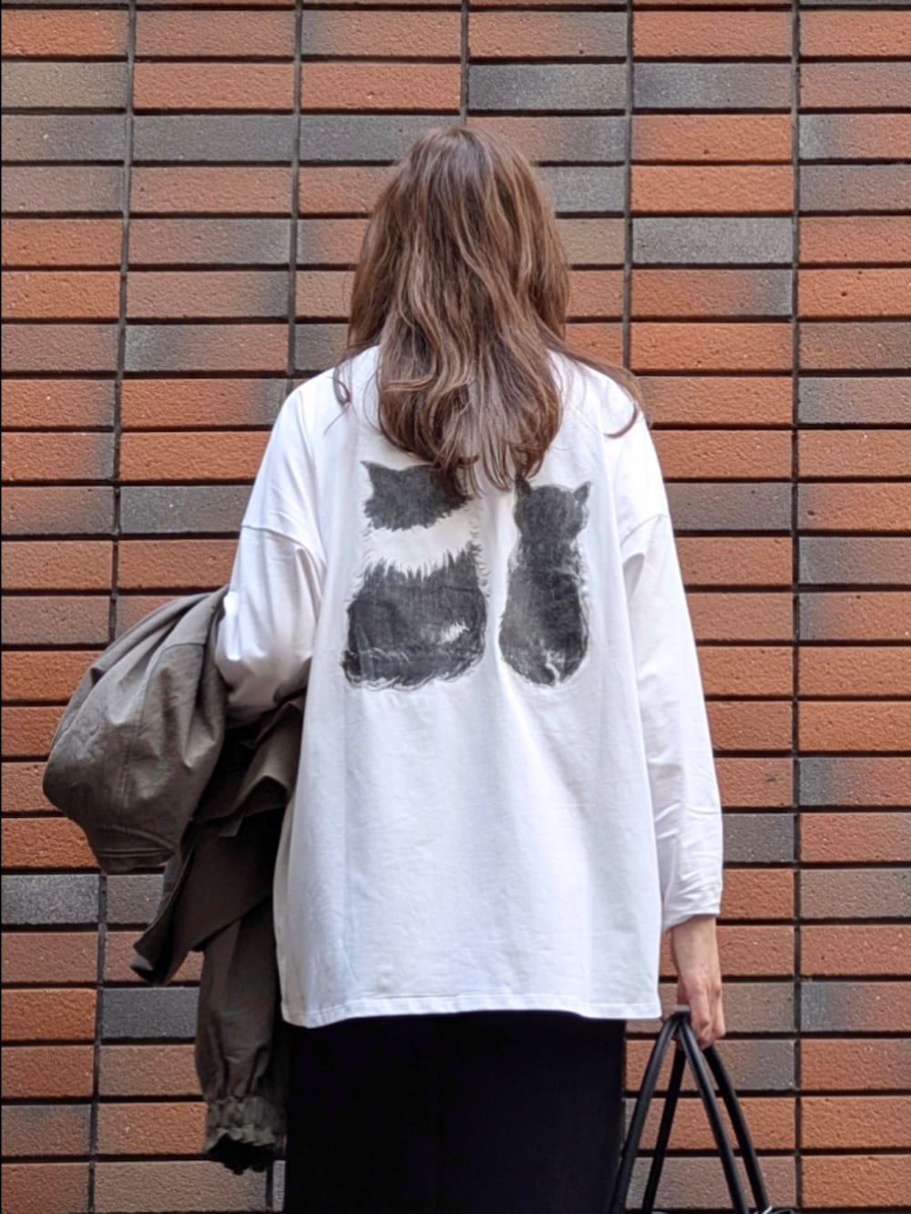 ブラック系のスカート、ホワイト系のTシャツ/カットソーを着用したレディースの冬コーディネートの7枚目の写真