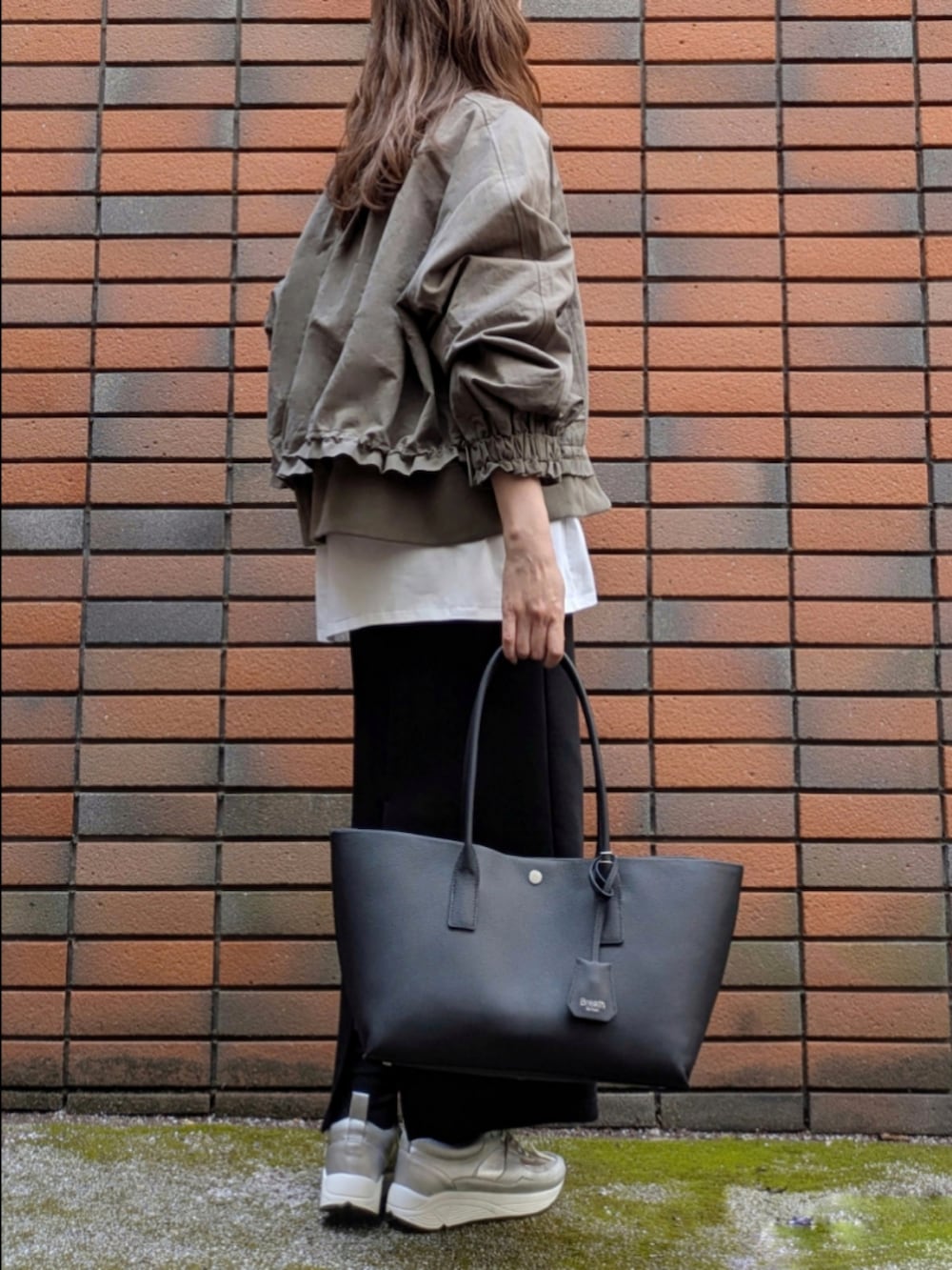 ブラック系のスカート、ホワイト系のTシャツ/カットソーを着用したレディースの冬コーディネートの3枚目の写真