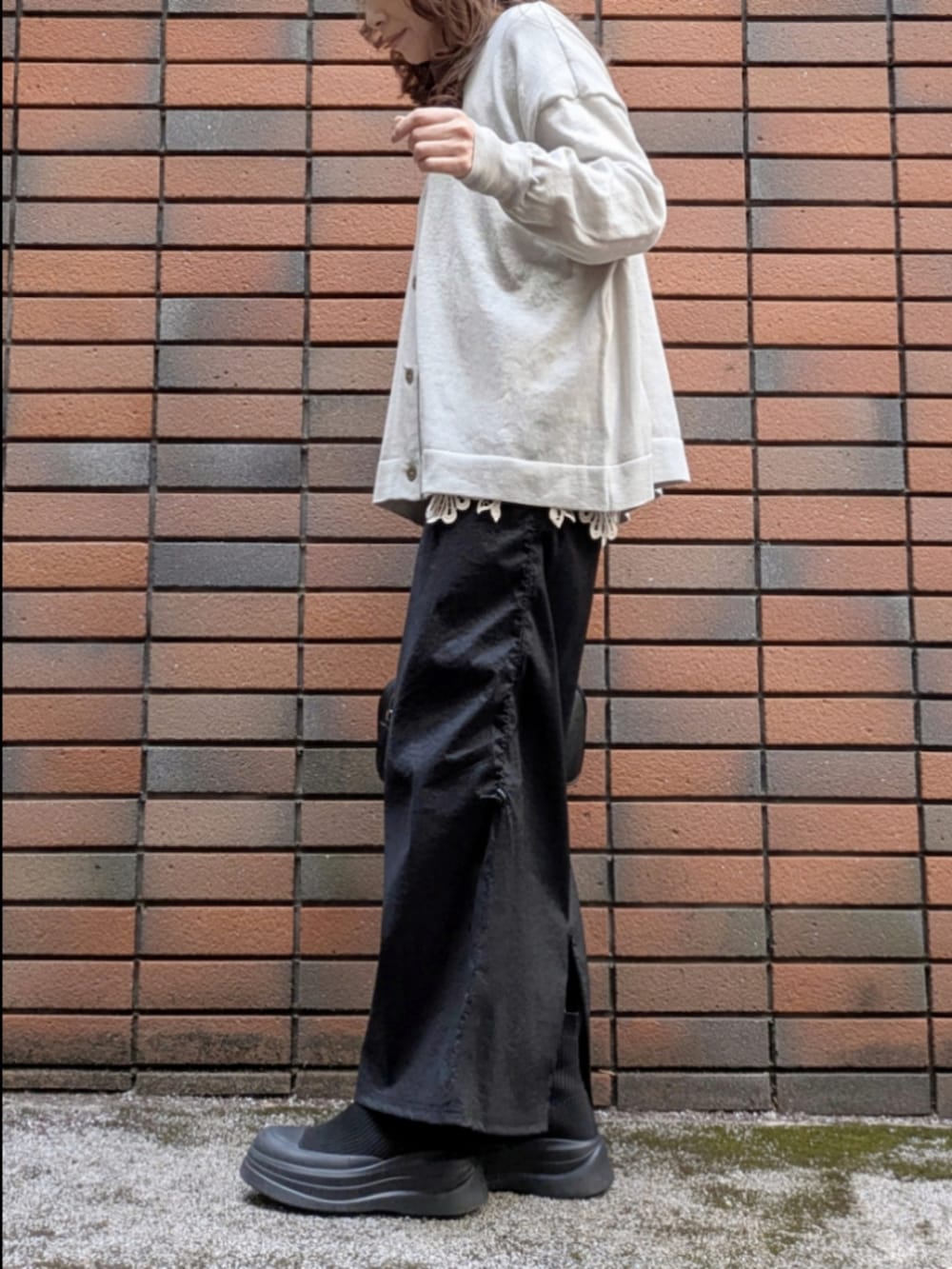 グレー系のニット/セーター、ベージュ系のTシャツ/カットソー、ブラック系のスカートを着用したレディースの冬コーディネートの5枚目の写真