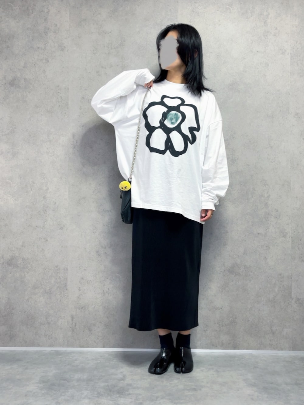 ホワイト系のTシャツ/カットソー、ブラック系のスカート、ブラック系のスリッポンを着用したレディースの秋コーディネートの2枚目の写真