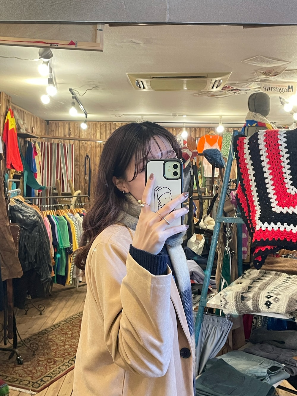 レッド系のボストンバッグ、ブルー系のニット/セーター、ホワイト系のスカートを着用したレディースの春コーディネートの2枚目の写真