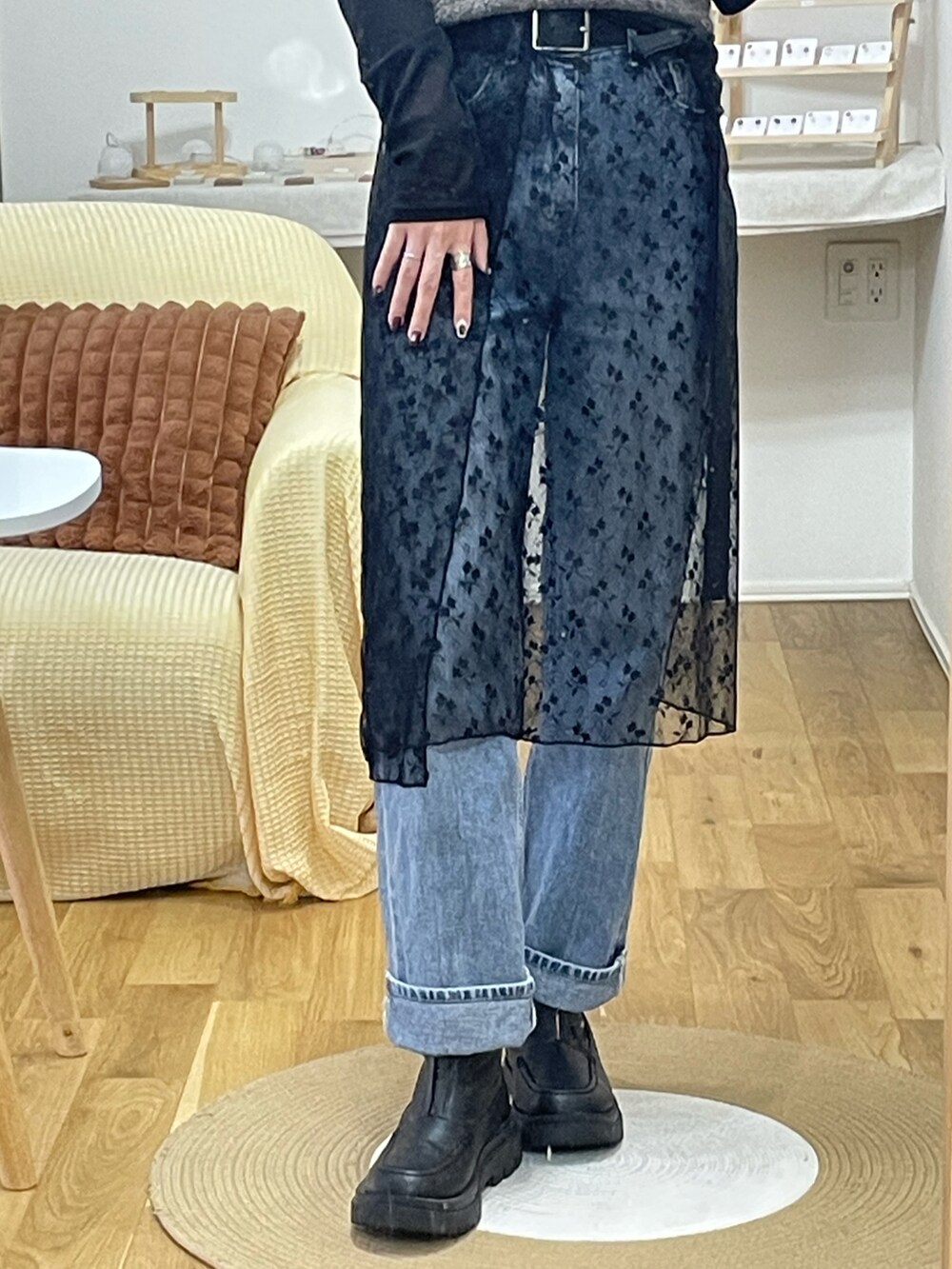 ブラウン系のニット/セーター、ブラック系のスカート、ブルー系のデニムパンツを着用したレディースの秋コーディネートの2枚目の写真